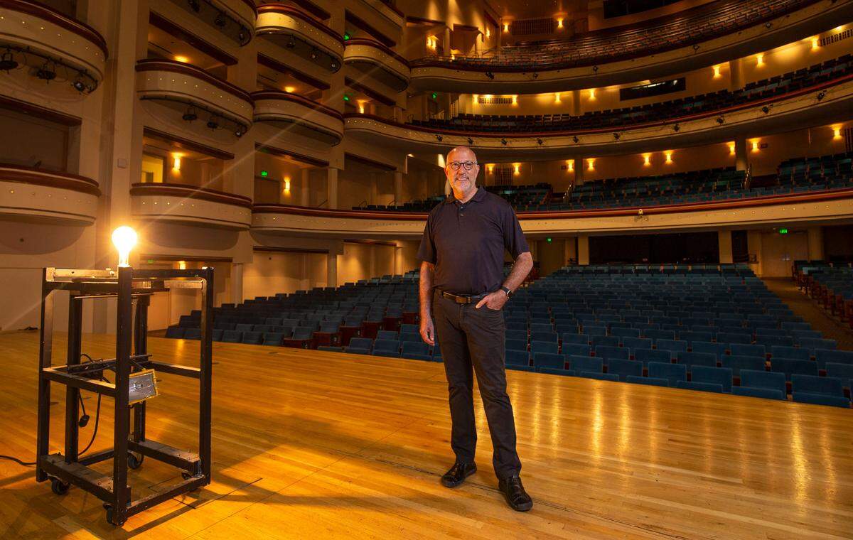 Tom Gabbard, president and CEO of Blumenthal Performing Arts, stands next to the “ghost light” used to illuminate the stage when other lights are off at the Belk Theatre in Charlotte. Superstition holds that the ghost light scares away spirits when no one is in the theater, which has been largely empty since March.