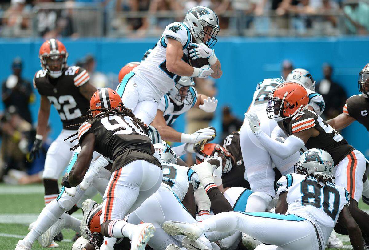 Carolina Panthers running back Christian McCaffrey leaps over the Cleveland Browns defensive line to score a touchdown during second quarter action at Bank of America Stadium on Sunday, September 11, 2022.