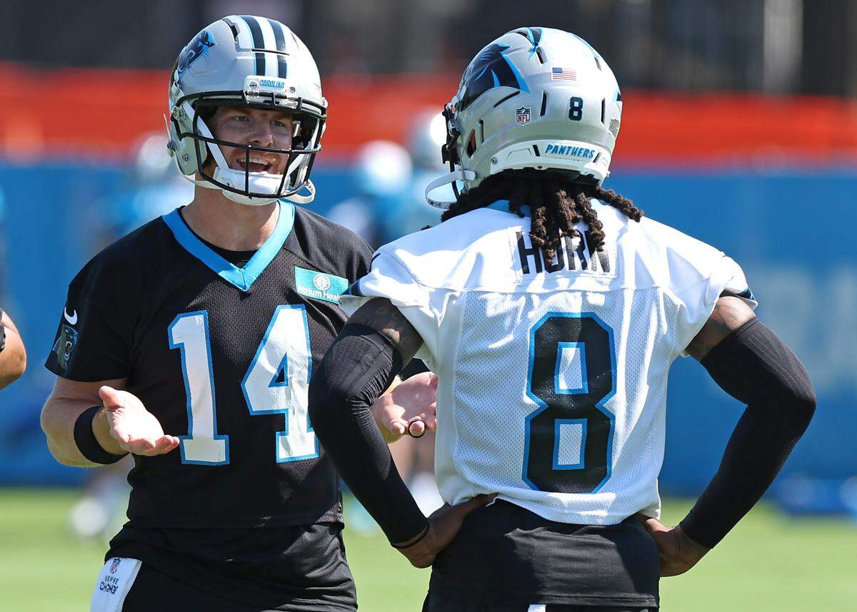Carolina Panthers quarterback Andy Dalton, left, talks to cornerback Jaycee Horn during a training camp practice on July 23, 2025 in Charlotte.