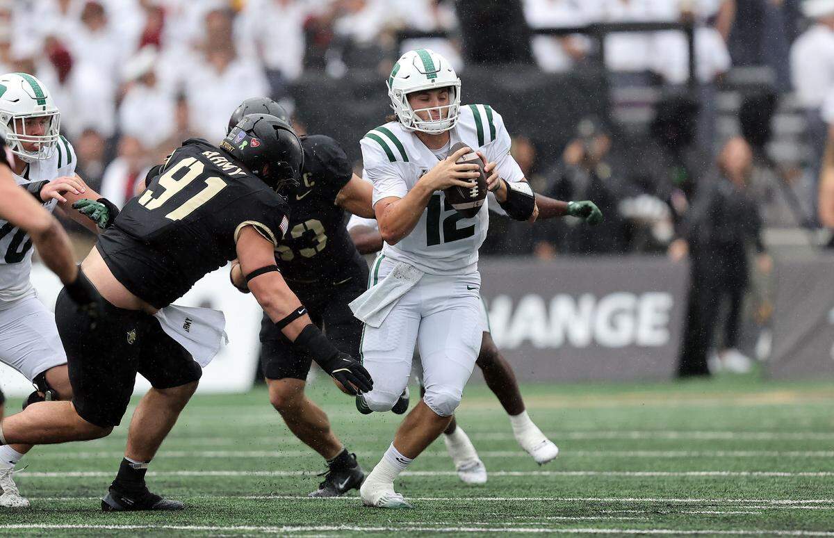 Charlotte 49ers quarterback Grayson Loftis tries to evade Army Black Knights defensive lineman Sean Donovan (91) during Saturday’s second half at Michie Stadium. 