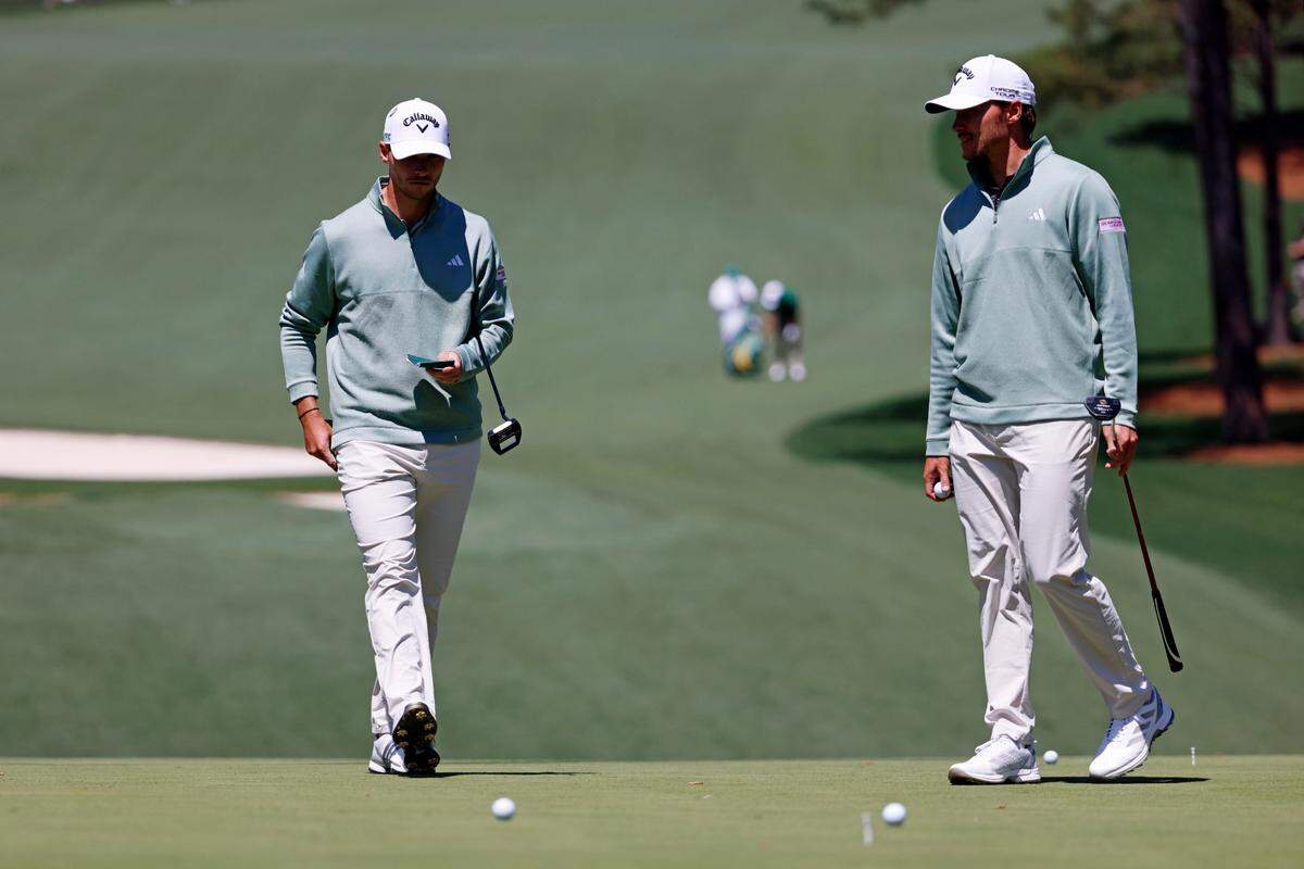Nicolai Hojgaard and Rasmus Hojgaard play on the 10th green during a practice round Tuesday for the Masters Tournament at Augusta National Golf Club. 