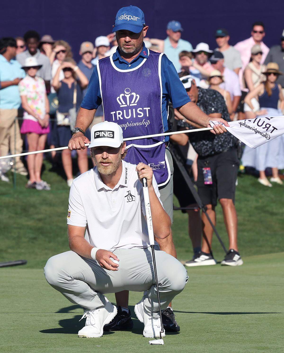 Golfer Kristoffer Reitan and his caddie, Tim Poyser, back, line up a putt on the 18th green during the final round of the Truist Championship at Quail Hollow Club in Charlotte, NC on Sunday, May 10, 2026. Reitan won the Truist Championship finishing at -15.