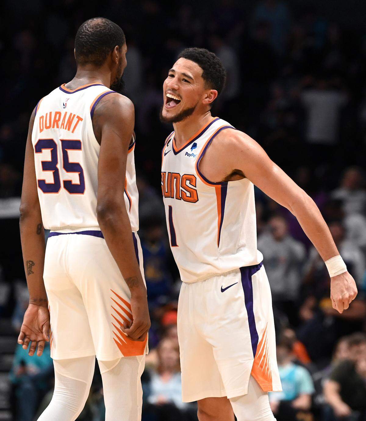 Phoenix Suns forward Kevin Durant, left and guard Devin Booker, right, celebrate the team’s 105-91 win over the Charlotte Hornets at Spectrum Center on Wednesday, February 1, 2023.