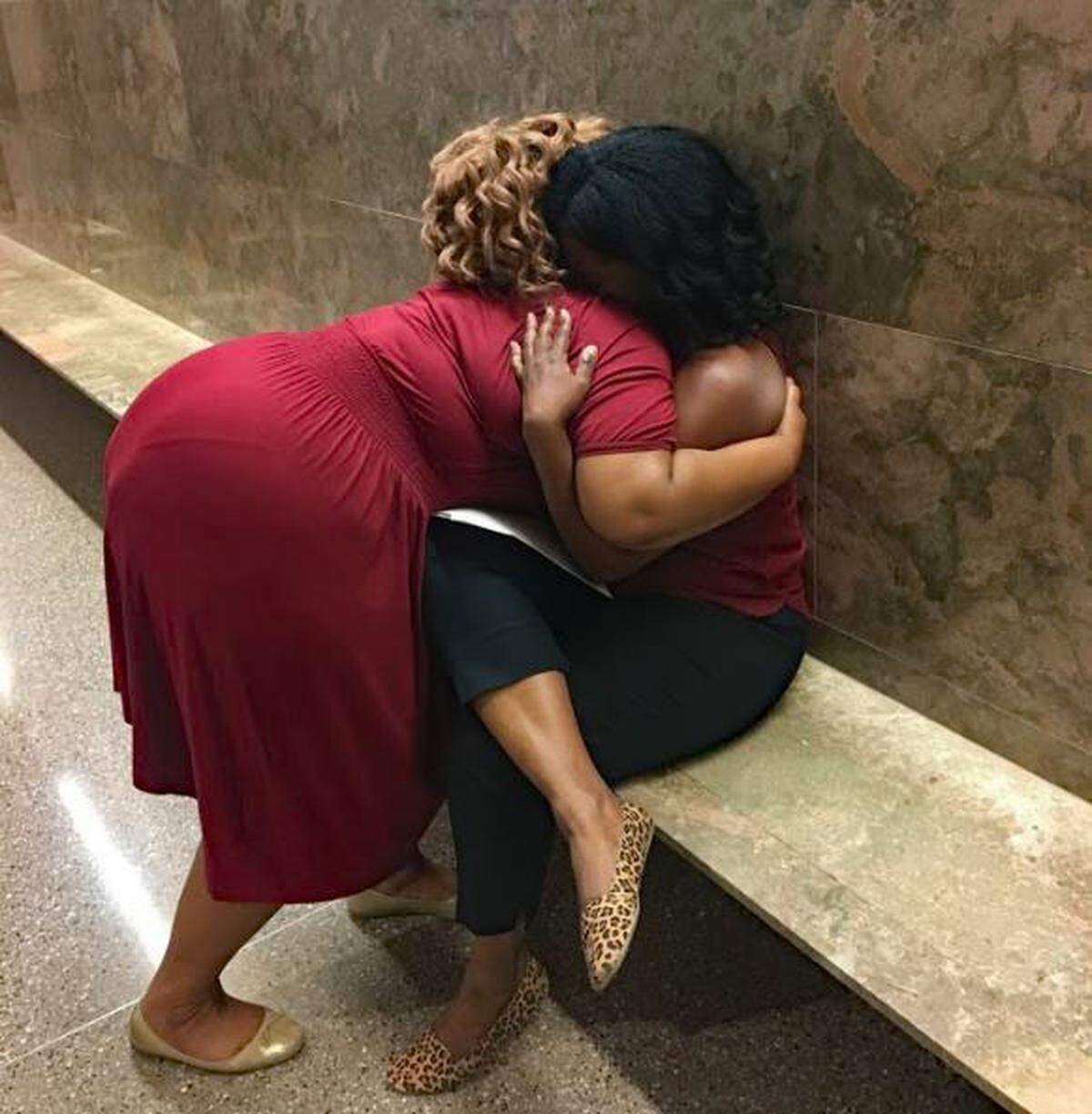 Waiting outside a courtroom for their eviction cases to be heard, Nikeia Diaz, left and Pat, strangers until today, offer support to each other.
