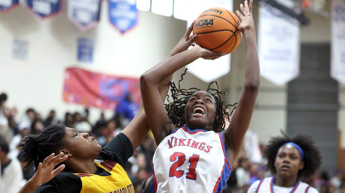 North Meck’s Mena Johnson, center, fights to get a shot off in the lane against West Charlotte defender Savanna Grimes, left, during action on Friday, February 13, 2026 at North Mecklenburg High School.