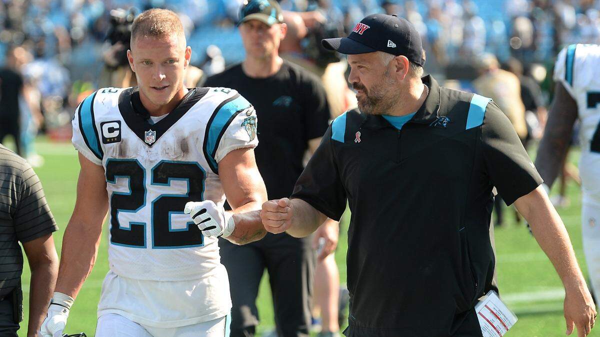 Carolina Panthers running back Christian McCaffrey, left and head coach Matt Rhule, right, bump arms after the 2021 season opener. McCaffrey has missed 23 of Carolina’s last 33 games, but he’s one of the best backs in the NFL when healthy.