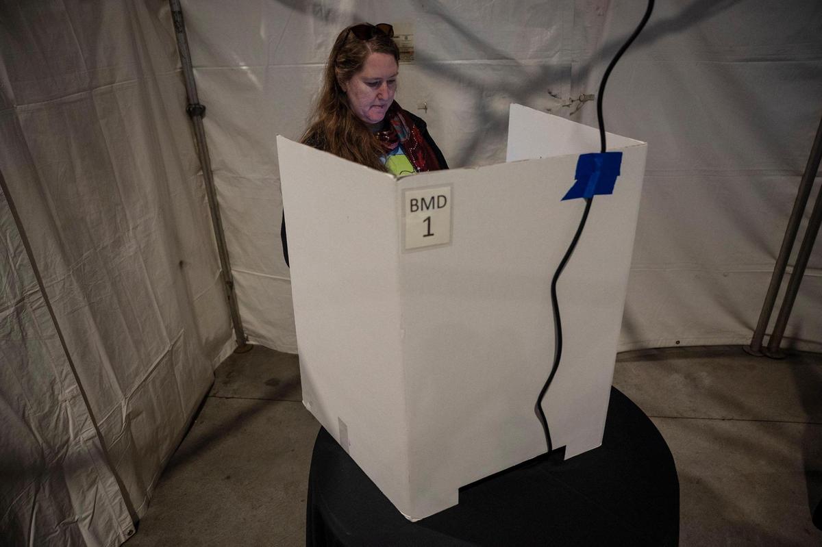 Shannon Gathman casts her ballot on the first day of early voting at Bank of America Stadium on Thursday, October, 20, 2022. Speaking on why she voted today, Gathman said “Get it done early, keep out of the lines, and I think voting is a responsibility. So it was easy today.”