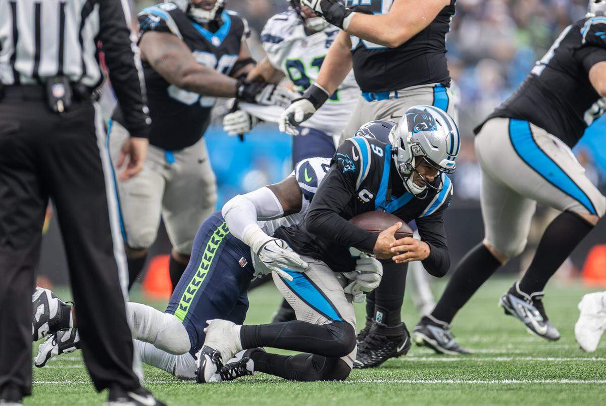 Carolina Panthers quarterback Bryce Young, right, is sacked by Seattle Seahawks defensive end Demarcus Lawrence at the Bank of America Stadium in Charlotte, N.C., on Sunday, Dec. 28, 2025.