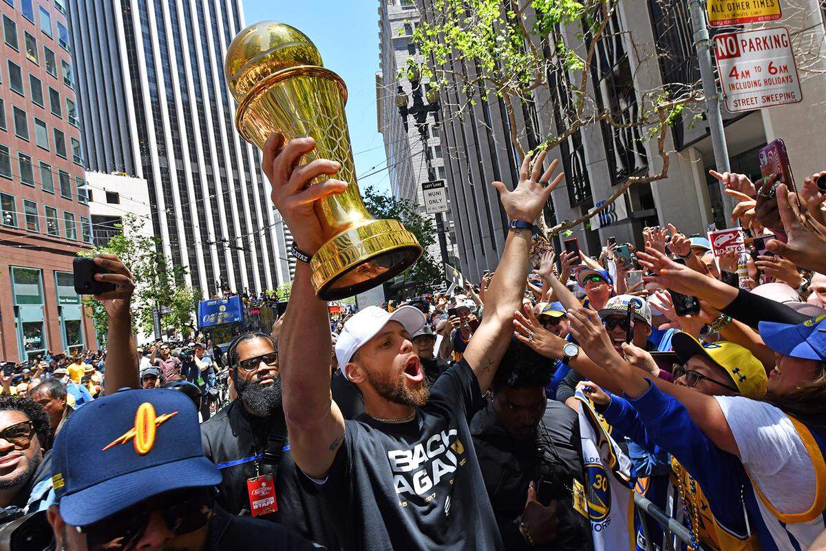 The Golden State Warriors’ Stephen Curry (30) holds the NBA Finals MVP trophy as he greets fans during the championship parade in San Francisco on Monday, June 20, 2022. Curry, who grew up in Charlotte, will host the ESPYS on July 20.&nbsp;
