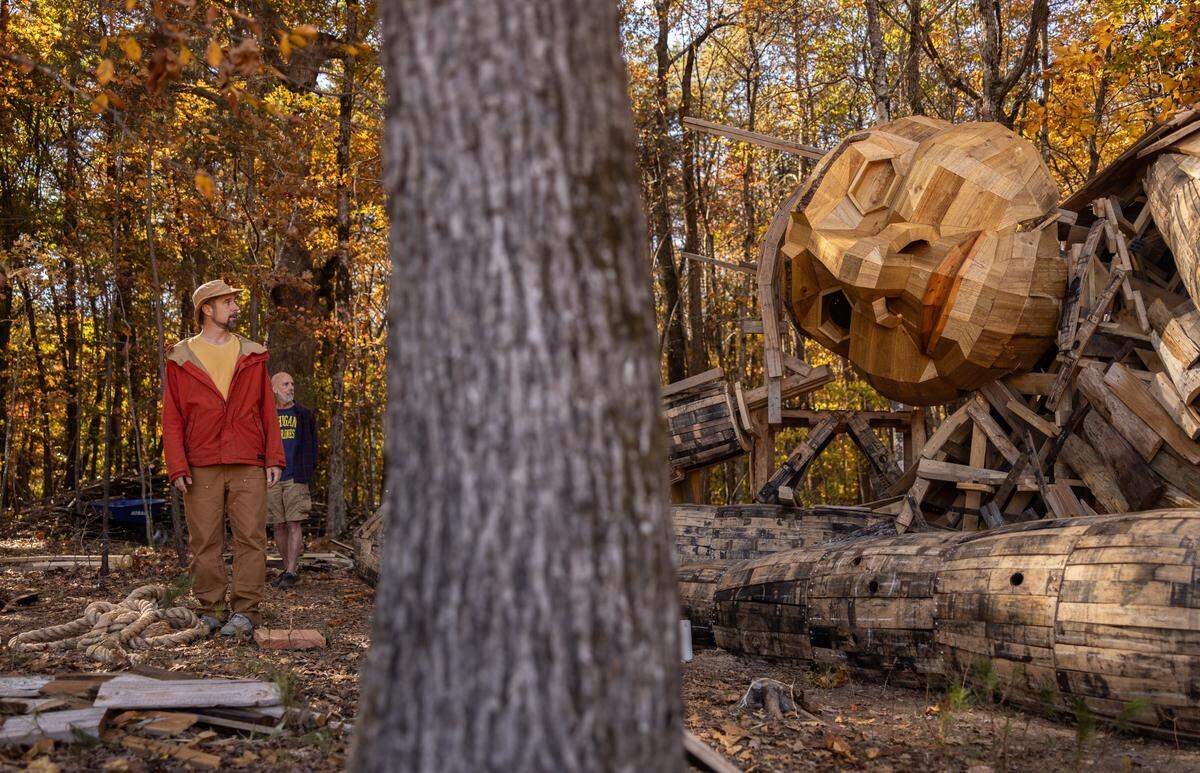 Danish artist Thomas Dambo watches volunteers work on constructing his giant troll sculpture named Pete with the Big Feet in Charlotte, N.C., on Thursday, November 6, 2025.