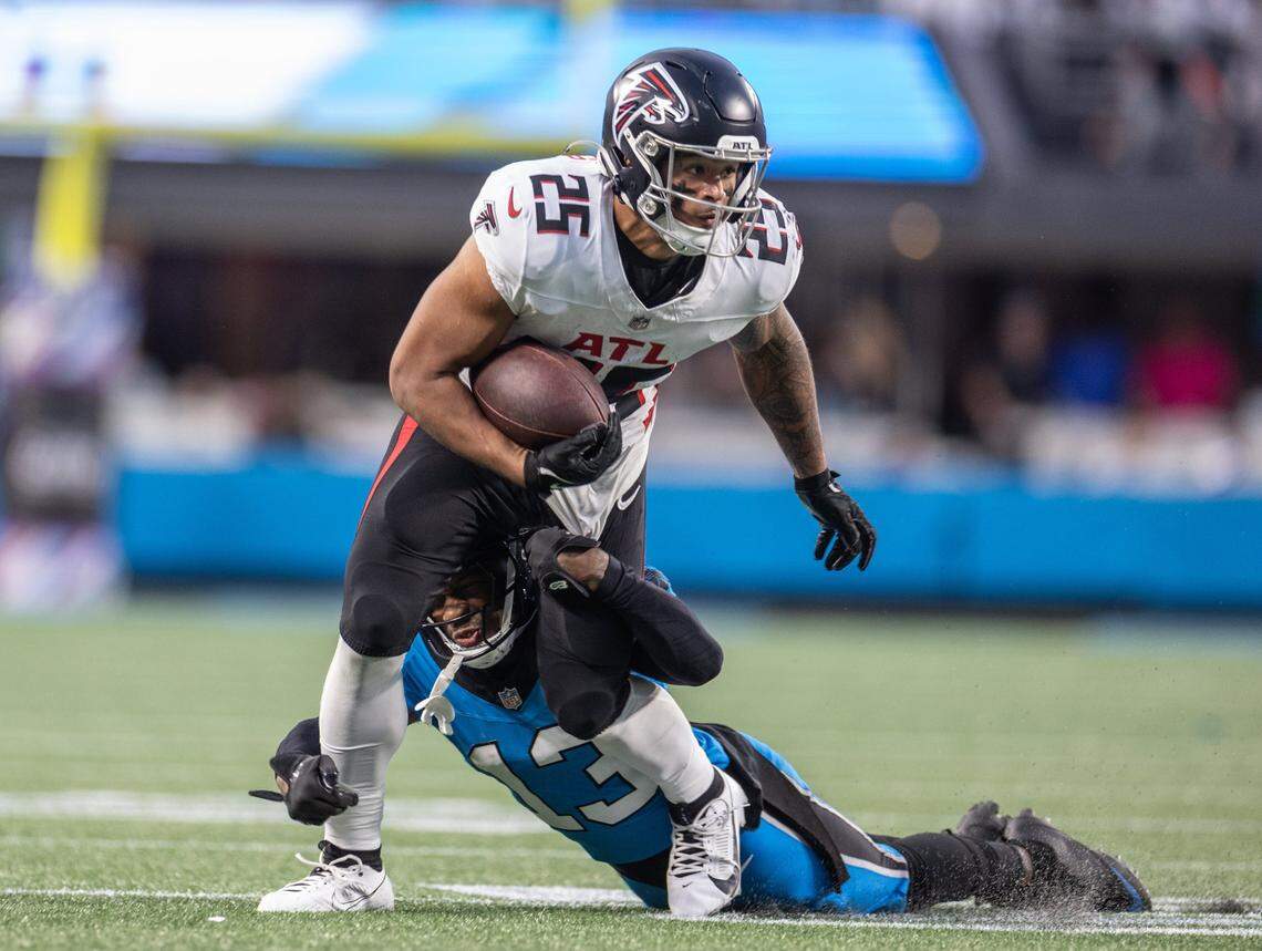 Atlanta Falcons running back Tyler Allgeier, left, is tackled by Carolina Panthers cornerback Troy Hill at the Bank of America Stadium in Charlotte, N.C. on Sunday, October 13, 2024.