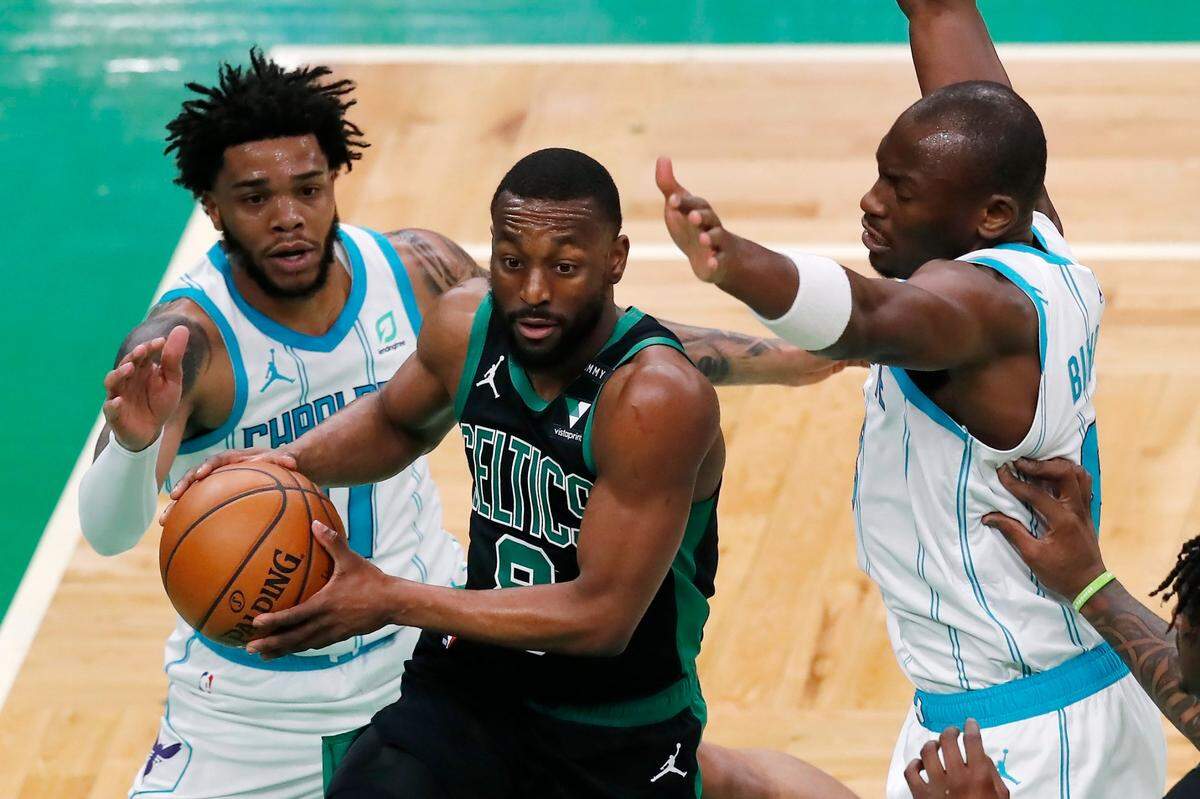 Boston Celtics’ Kemba Walker (8) drives between Charlotte Hornets’ Miles Bridges (0) and Bismack Biyombo, right, during the first half of an NBA basketball game Sunday, April 4, 2021, in Boston. (AP Photo/Michael Dwyer)