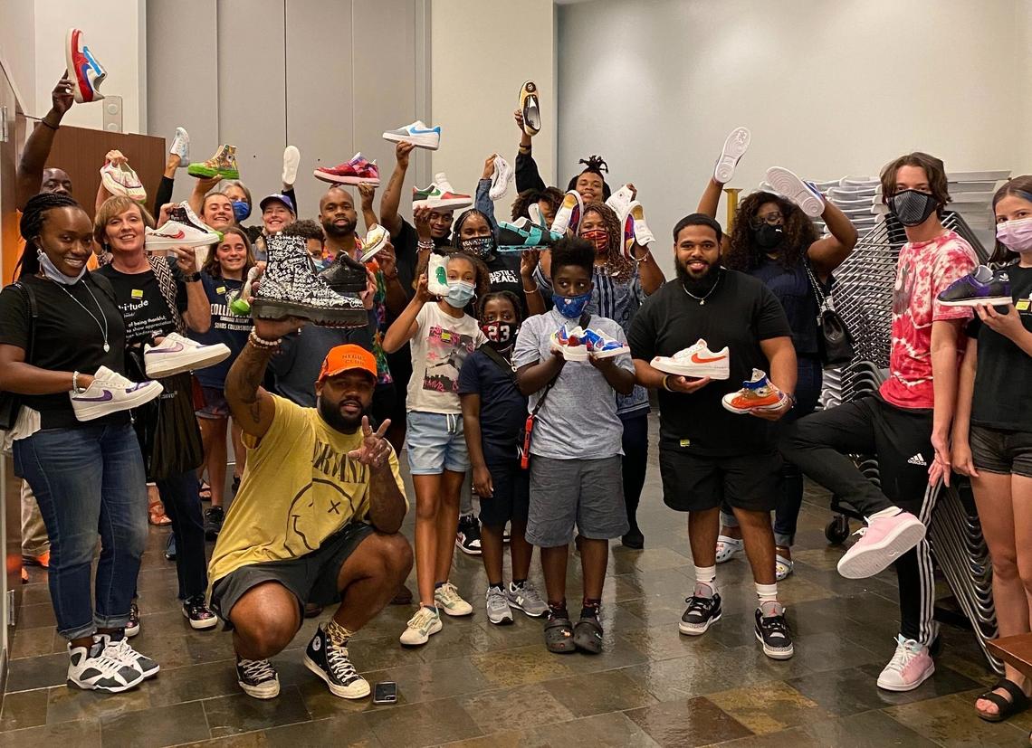 Spartanburg artist Frankie Zombie (squatting at bottom left) posing with the students in his “Colorfully Custom” sneaker painting class at the Harvey B. Gantt Center for African-American Arts + Culture in Uptown Charlotte.