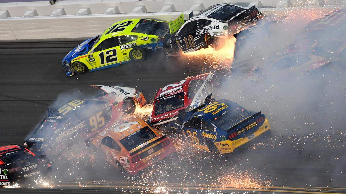 NASCAR Cup Series drivers Ryan Blaney (12), Aric Almirola (10), Paul Menard (21), NASCAR Cup Series driver David Ragan (38), Austin Dillon (3), Daniel Suarez (41), Matt Dibenedetto (95), Tyler Reddick (31), and Ryan Newman (6) crash during the 2019 Daytona 500 at Daytona International Speedway.