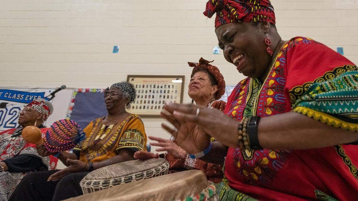 Barbarette Talley, right, of the Queen City Senior African Drummers, plays the djembe alongside several of her groupmates for a crowd of young children during the Juneteenth Festival of the Carolinas culture day camp Thursday, June 16, 2022, at Elizabeth Traditional Elementary School in Charlotte, N.C.