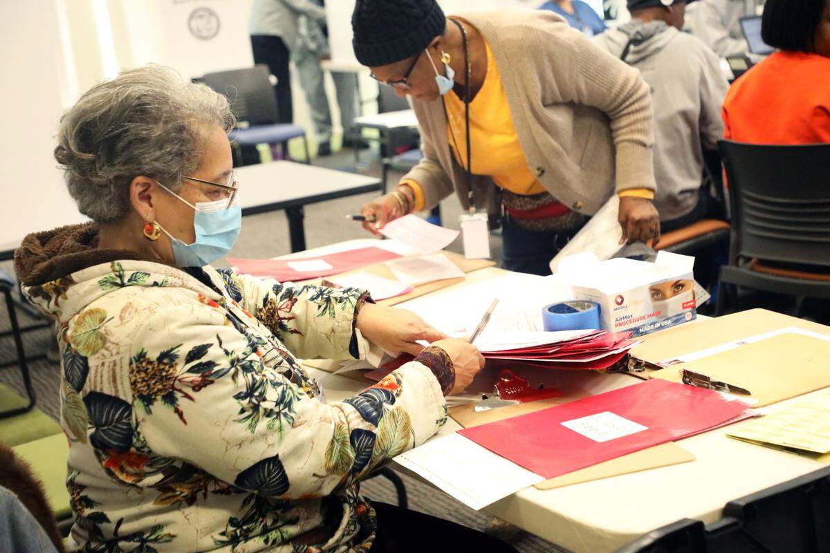 Election officials serve voters during early voting at the Allegra Westbrooks Regional Library in Charlotte, N.C. on October 17, 2024.