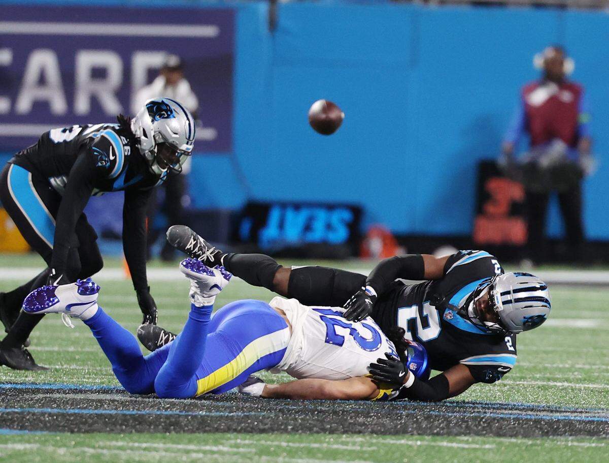 Carolina Panthers cornerback Chau Smith-Wade (26) and Mike Jackson (2) take down Los Angeles Rams wide receiver Puka Nacua in Saturday’s game against the Rams at Bank of America Stadium.