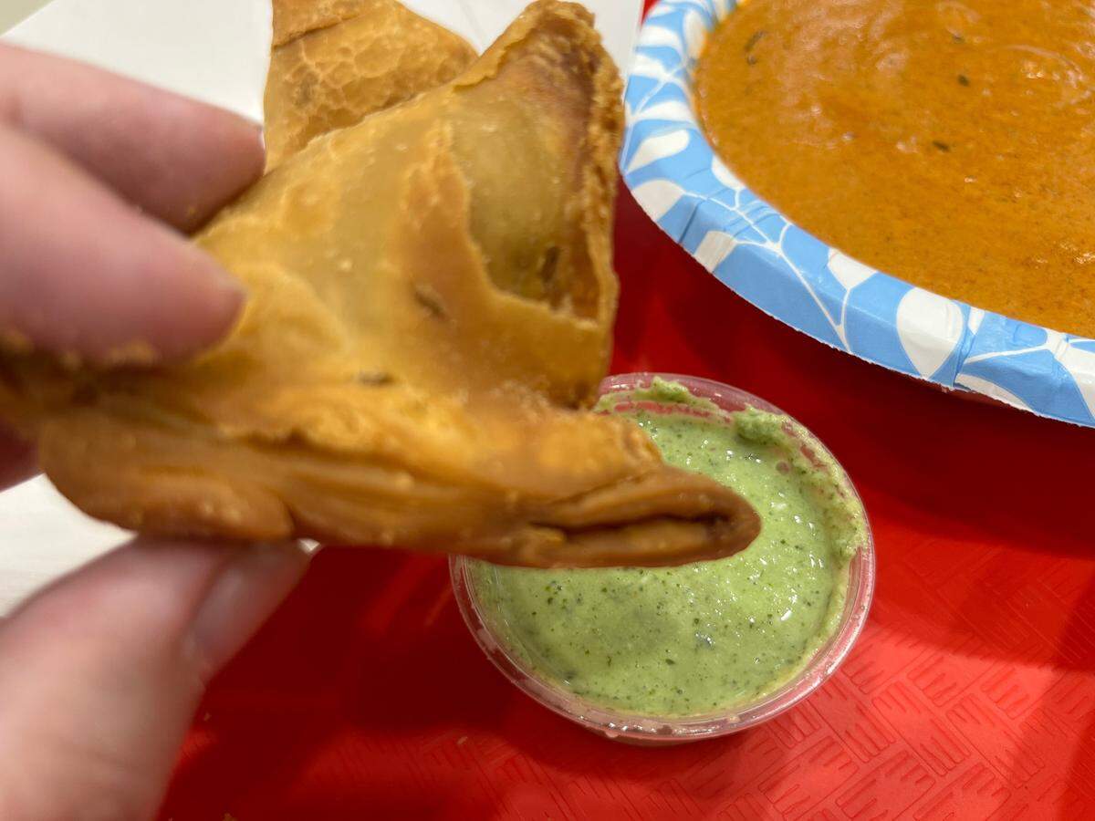 An order of Triveni’s samosas come with three hefty pieces, along with green chutney for dipping.