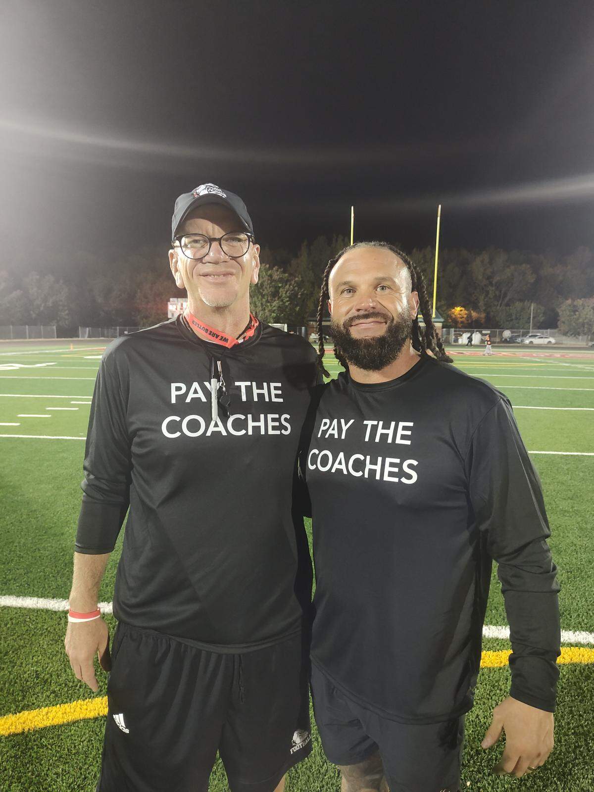 Butler High football coach Brian Hales (left) and West Charlotte’s Sam Greiner were among a large group of Charlotte-Mecklenburg Schools coaches that wore black shirts to silently protest over what they feel is poor coaches’ pay.