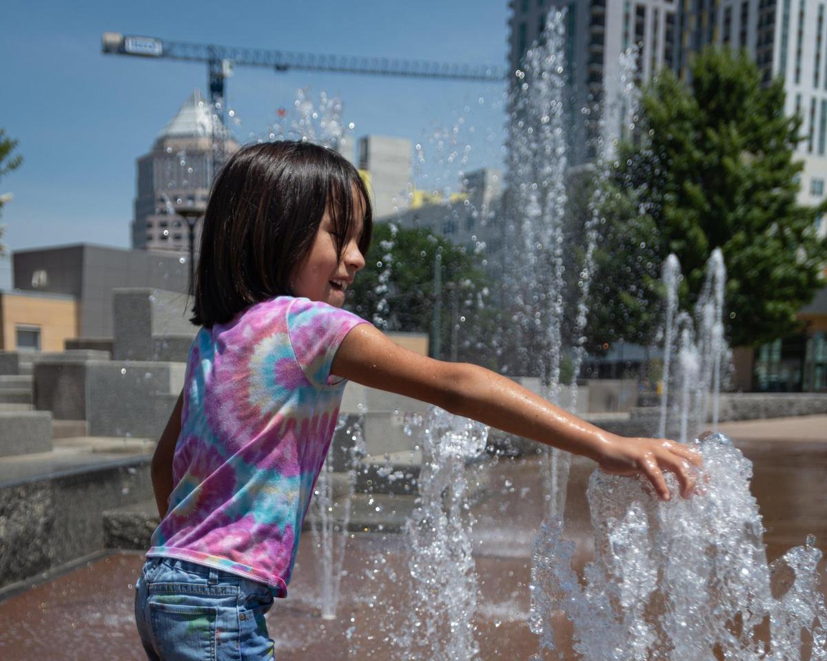 Jennica Perez, 7, plays with the water at First Ward Park sprayground in uptown Charlotte, NC, on Monday, June 13, 2022.