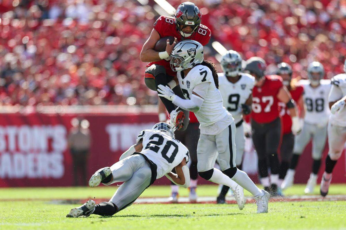 Dec 8, 2024; Tampa, Florida, USA; Tampa Bay Buccaneers tight end Cade Otton (88) is stopped by Las Vegas Raiders safety Tre'von Moehrig (7) in the first quarter at Raymond James Stadium. Mandatory Credit: Nathan Ray Seebeck-Imagn Images