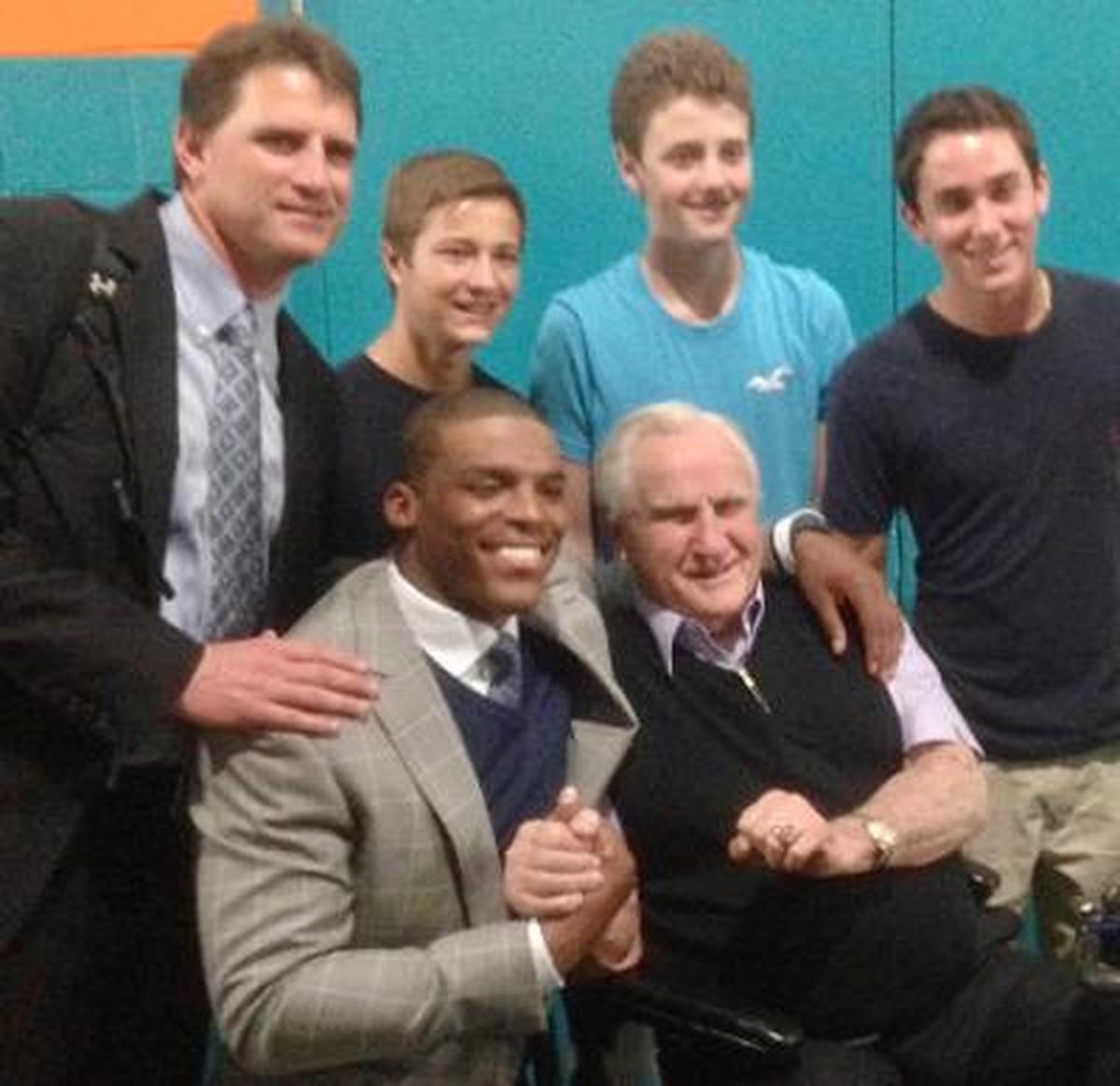 In 2013, after a Carolina Panthers victory over the Miami Dolphins in Florida, Cam Newton (left, seated) and former Dolphins coach Don Shula posed for a photo together. Mike Shula (far left, standing) was the Panthers’ offensive coordinator at the time.