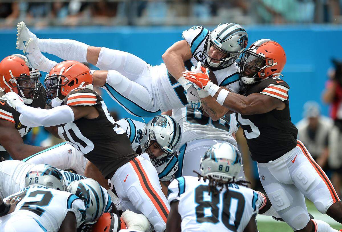Carolina Panthers running back Christian McCaffrey leaps over the Cleveland Browns defensive line to score a touchdown during second quarter action at Bank of America Stadium on Sunday, September 11, 2022.