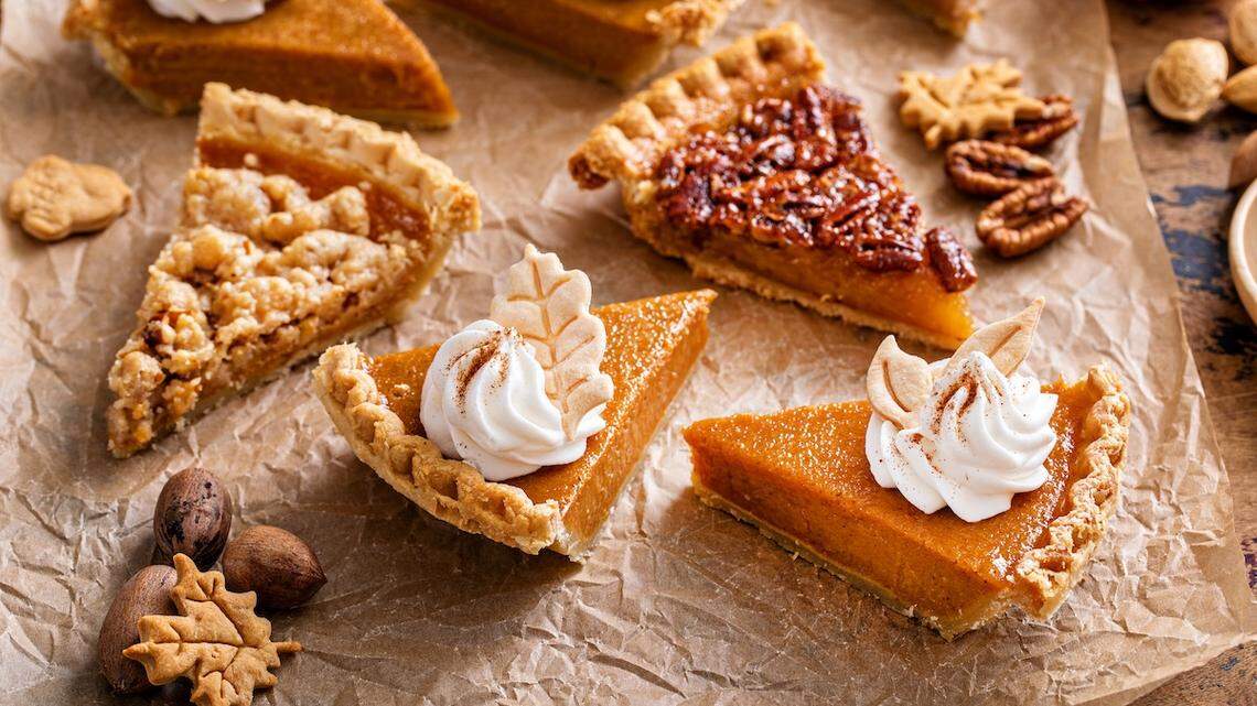 Thanksgiving pies slices on parchment paper, pumpkin and pecan pie