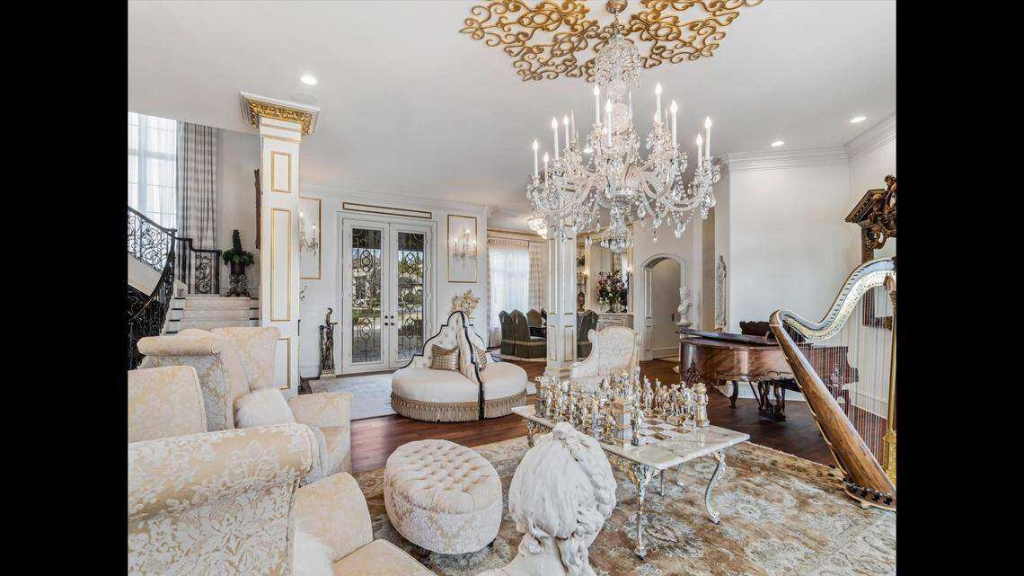 The living room of the home features a Bocra chandelier made in only two places in the world, according to the listing. An 8-foot gold medallion surrounds the chandelier to match the front door​.