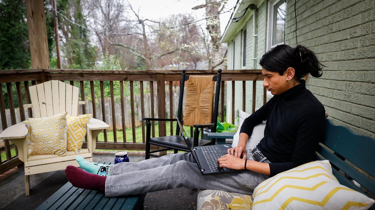 Arturo Pineda of Charlotte works on a laptop on their back porch in Charlotte. Pineda left their former job in 2021. “Living in the middle of a pandemic and having the necessity for health care was a really scary thing, knowing that I might not be able to afford it.”