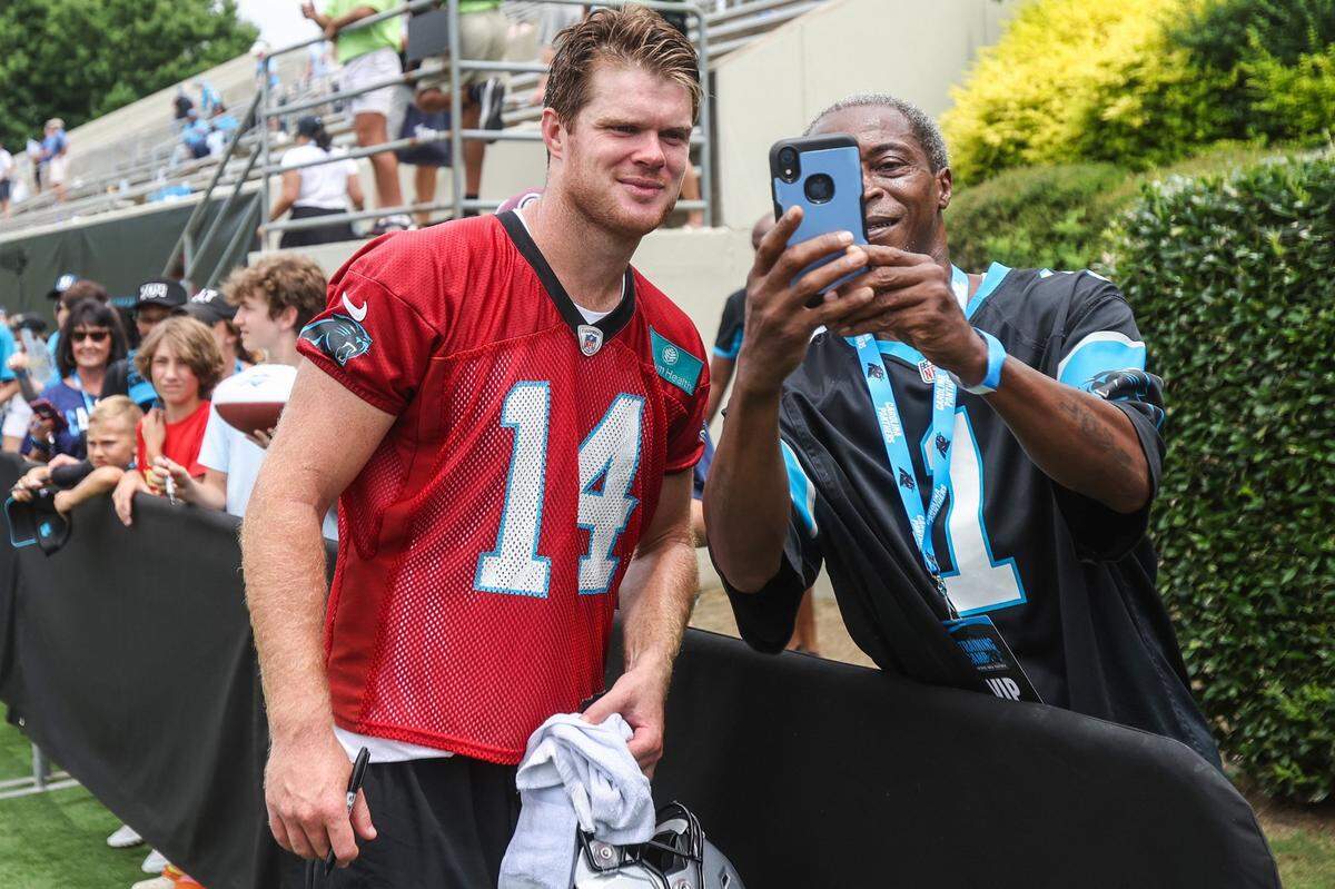 Panthers quarterback Sam Darnold, left, poses for a selfie with a fan after the Back Together practice in Gibbs Stadium at Wofford College on Saturday, July 30, 2022 in Spartanburg, SC.