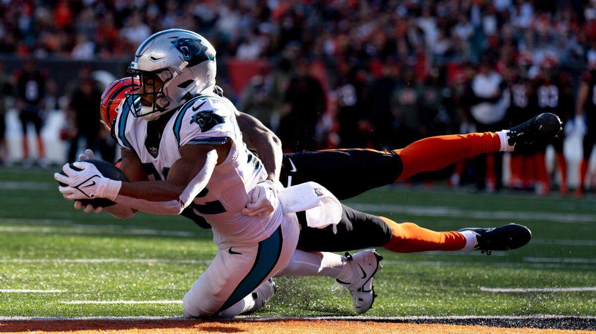 Carolina Panthers tight end Tommy Tremble catches a touchdown pass as Cincinnati Bengals safety Dax Hill (23) attempts to stop him in a 2022 game. Albert Cesare/The Enquirer