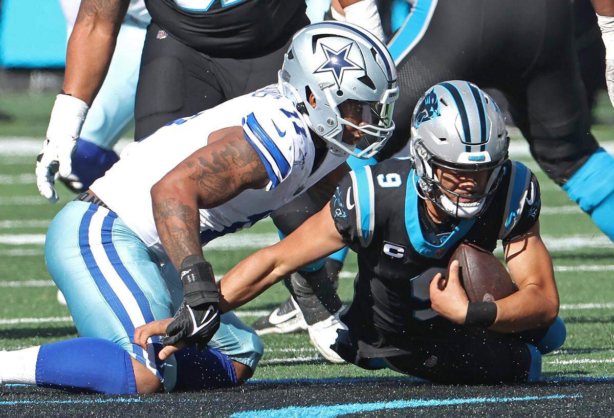 Dallas Cowboys linebacker Micah Parsons, left, sacks Carolina Panthers quarterback Bryce Young, right, during first-quarter action at Bank of America Stadium in Charlotte, NC on Sunday, November 19, 2023.