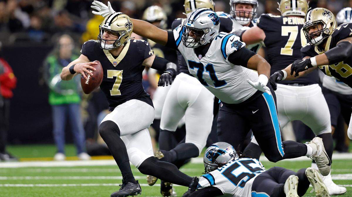 New Orleans Saints tight end Taysom Hill (7) runs the ball past Carolina Panthers defensive tackle Phil Hoskins (71) during an NFL football game, Sunday, Jan. 8, 2023, in New Orleans. (AP Photo/Tyler Kaufman)