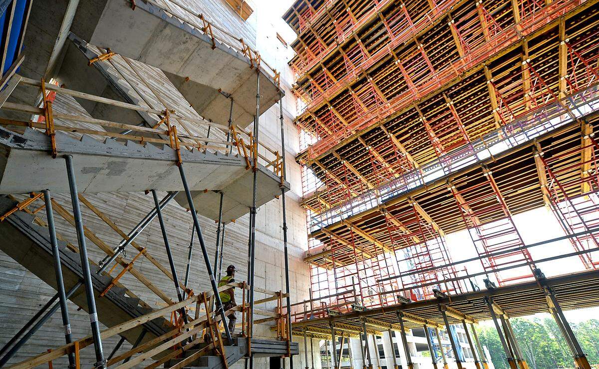 A construction worker, left, climbs a set of stairs in a lobby area of what was to be the 800,000-square-foot Centene Corp. East Coast headquarters at University City Research Park in Charlotte in this 2021 file photo.