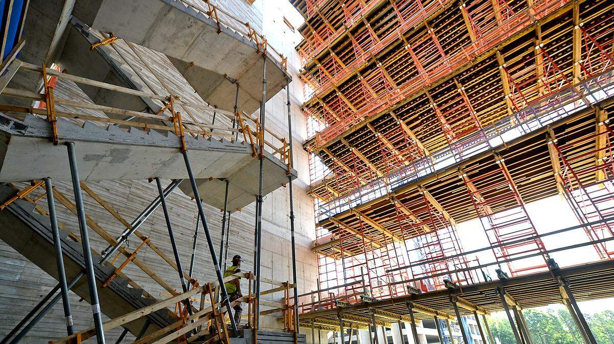 A construction worker, left, climbs a set of stairs in a lobby area of the 800,000-square-foot Centene Corp. East Coast headquarters at University City Research Park in Charlotte.