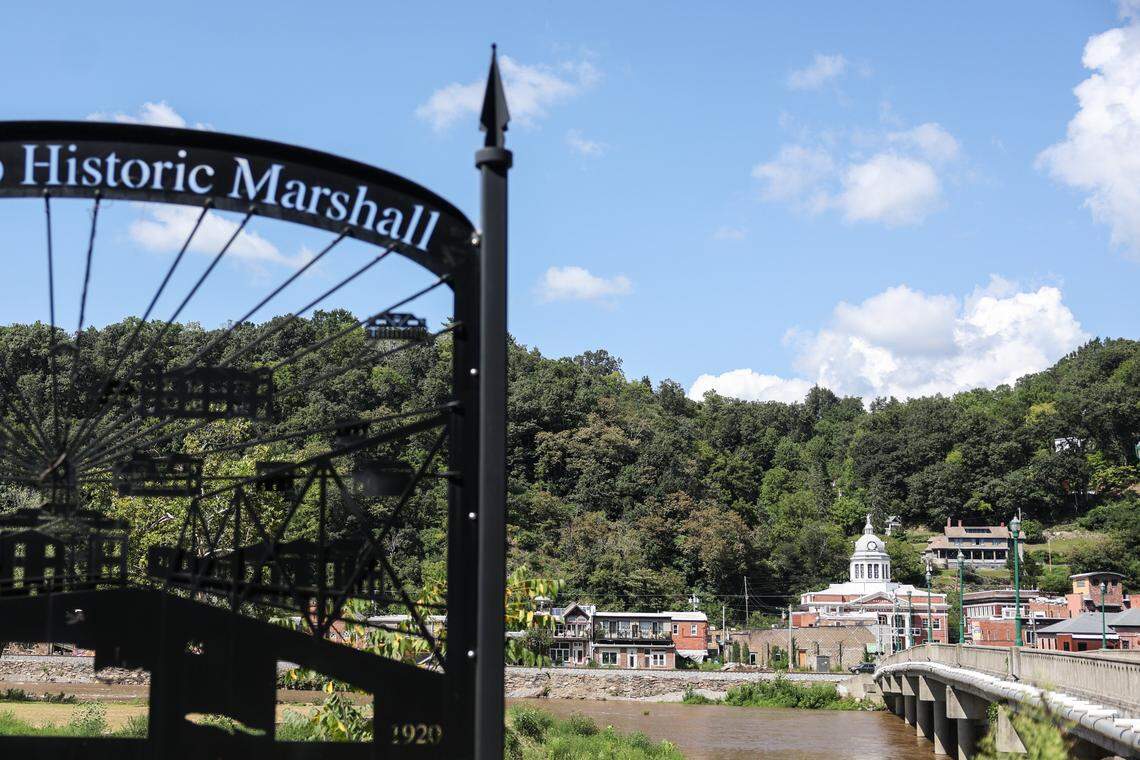 A sign for Marshall’s historic downtown greets people on the other side of the French Broad River, which flooded to historic levels last year during Helene.