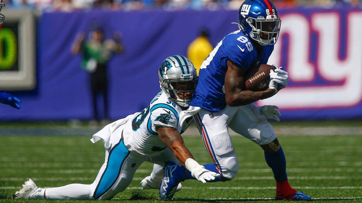 New York Giants’ Kadarius Toney, right, tries to avoid a tackle by Carolina Panthers’ Myles Hartsfield during the first half an NFL football game, Sunday, Sept. 18, 2022, in East Rutherford, N.J. (AP Photo/John Munson)