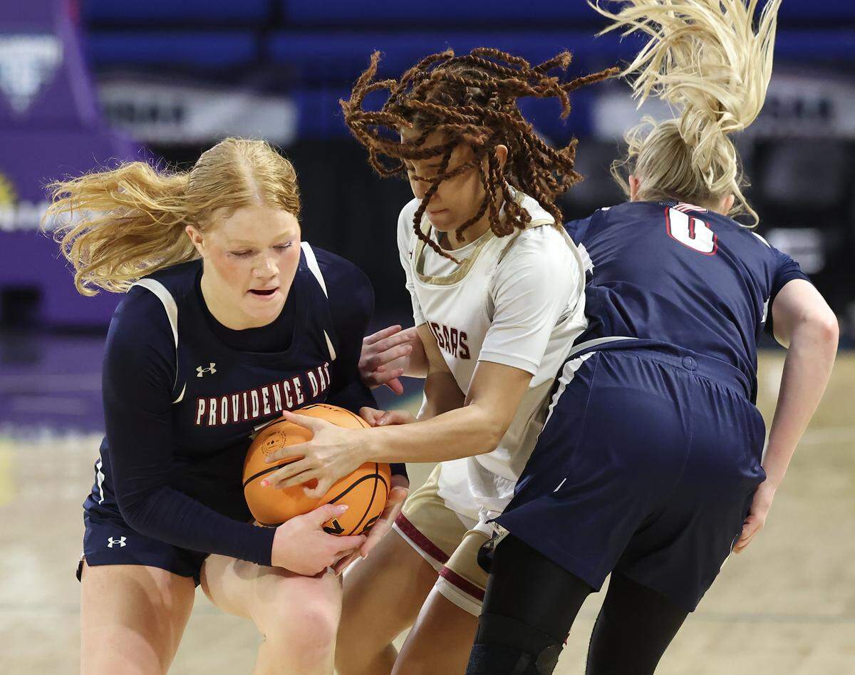 Cannon School’s Mackenzie Larkins, center, fights to strip the ball from Providence Day’s Jane Updyke, left, and Ginny Anne Dumont, right, during action in the NCISAA girls state championship game on Saturday, February 28, 2026 at Novant Fieldhouse in Greensboro, NC. . 