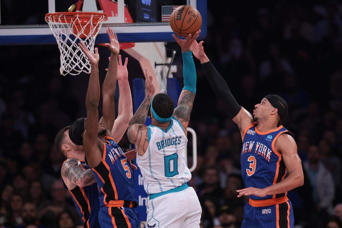 Charlotte Hornets forward Miles Bridges (0) drives to the basket asNew York Knicks guard Josh Hart (3) and guard Immanuel Quickley (5) defend during the first half at Madison Square Garden. 