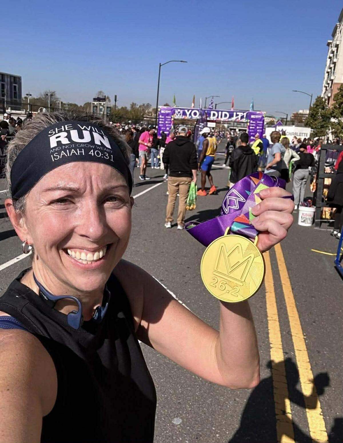 Leigh Thomas Brown shows off her medal after setting a personal-best marathon time in Charlotte in November 2023.