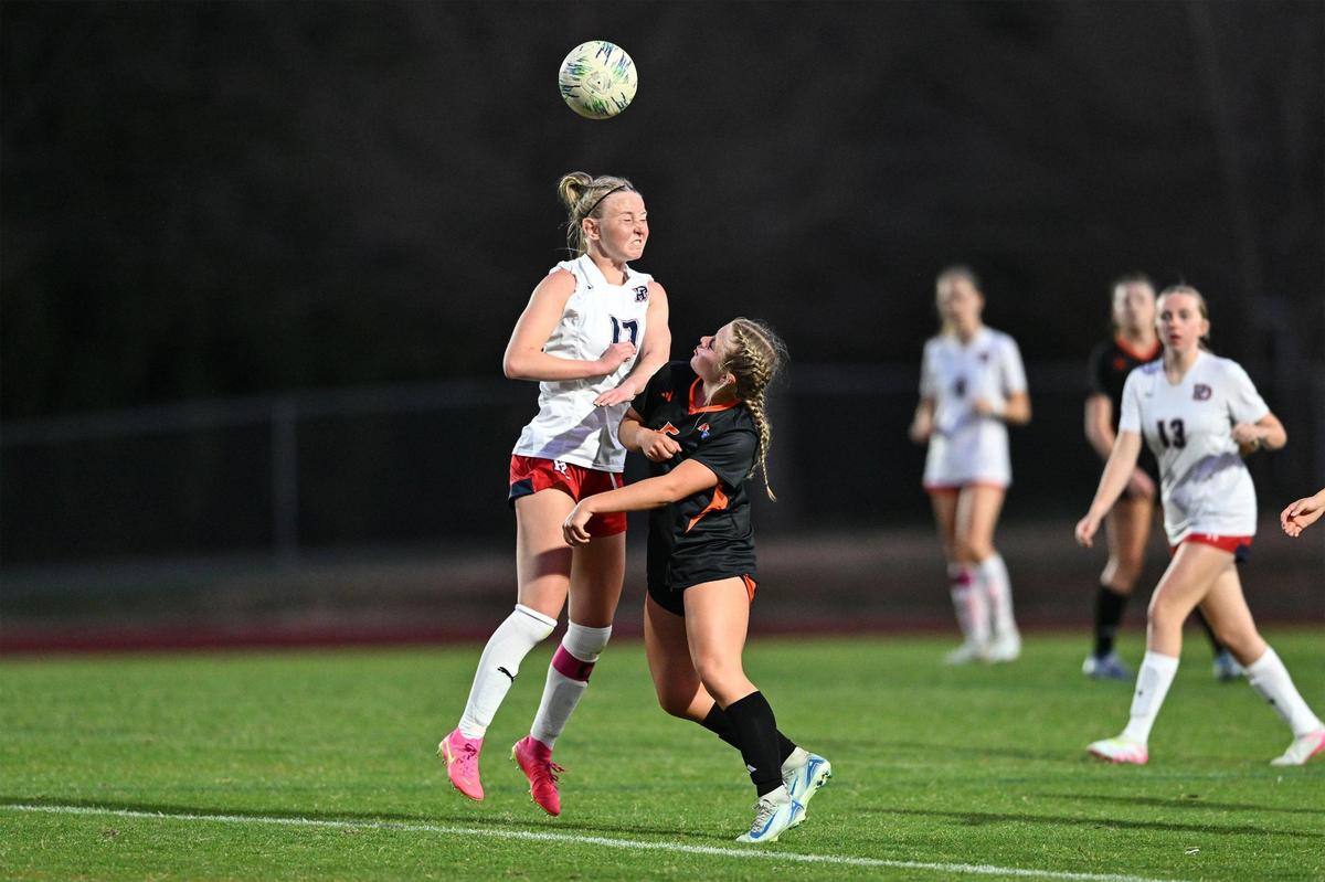 Providence Day’s Blane McElroy (17) heads the ball away from Marvin Ridge’s Isabel Reist (5) during the first half of a varsity soccer match, Tuesday, March 25, 2025, in Charlotte, N.C. (Charlotte Observer/Matt Kelley)
