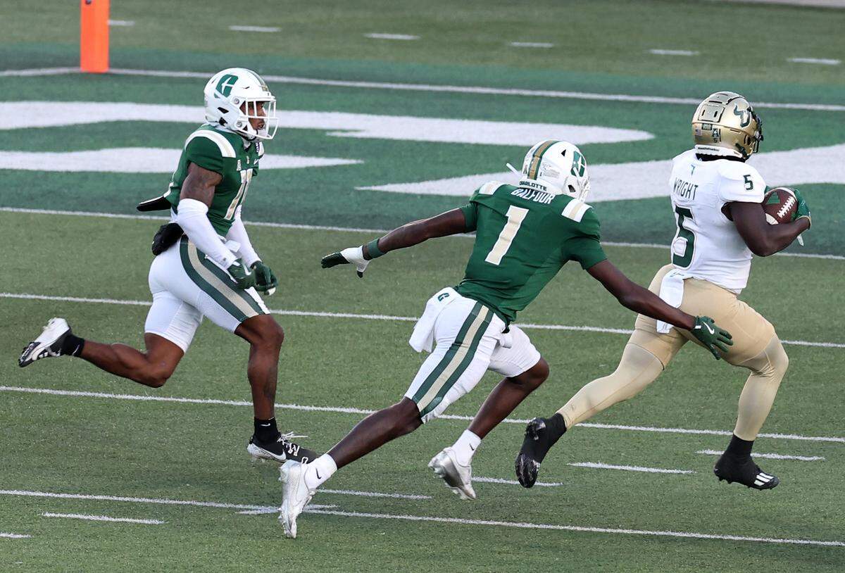 Charlotte 49ers defensive backs Elijah Culp, left and Dontae Balfour, center, chase South Florida running back Nay’Quan Wright, right, on a long run during action on Saturday, November 16, 2024 at Jerry Richardson Stadium.