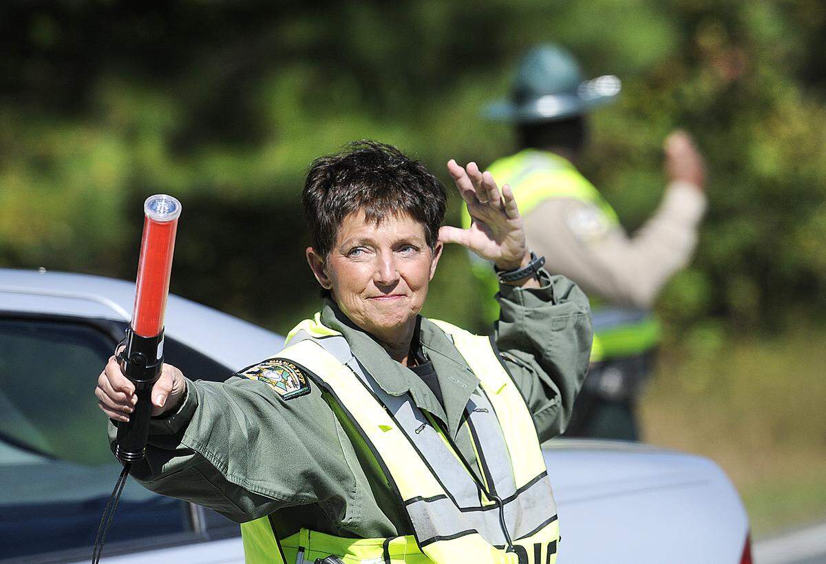 Sylvia Deese, a deputy with the Mecklenburg County Sheriff's Department, directs traffic coming into and going out of the Mallard Creek BBQ on Thursday October 23, 2014.