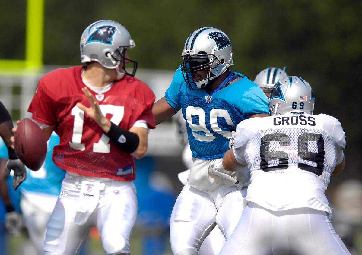 Panthers defensive end Julius Peppers (center) tries to work around tackle Jordan Gross (#69) to get to quarterback Jake Delhomme (#17) on Tuesday afternoon during Panthers Training Camp at Wofford College in Spartanburg, SC. DAVID T. FOSTER III-dtfoster@charlotteobserver.com