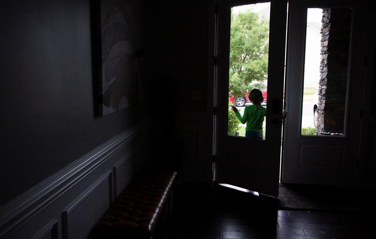 After playing outside one of Peter Mutabazi’s foster kids stands in the doorway of their Charlotte home before heading inside on Wednesday, June 5, 2023.