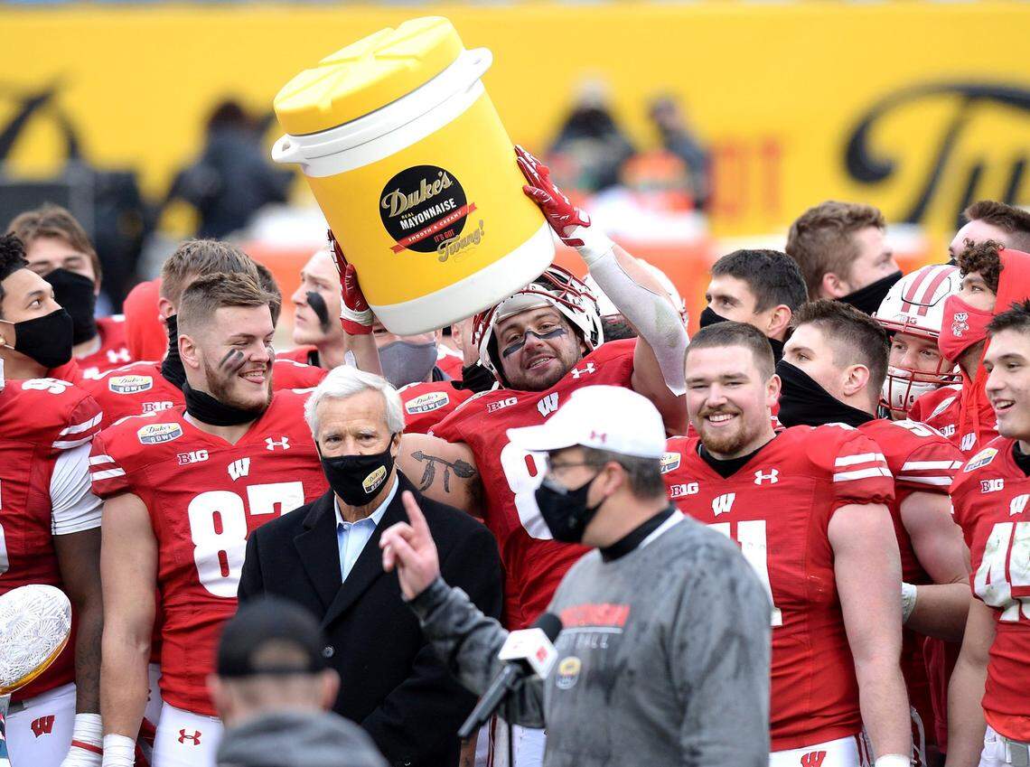 A Wisconsin Badgers player playfully hoists a water container featuring the label for Duke’s Mayo above his head as he and his teammates celebrate their 42-28 victory over Wake Forest in the Duke’s Mayo Bowl at Bank of America Stadium in Charlotte on Dec. 30, 2020.