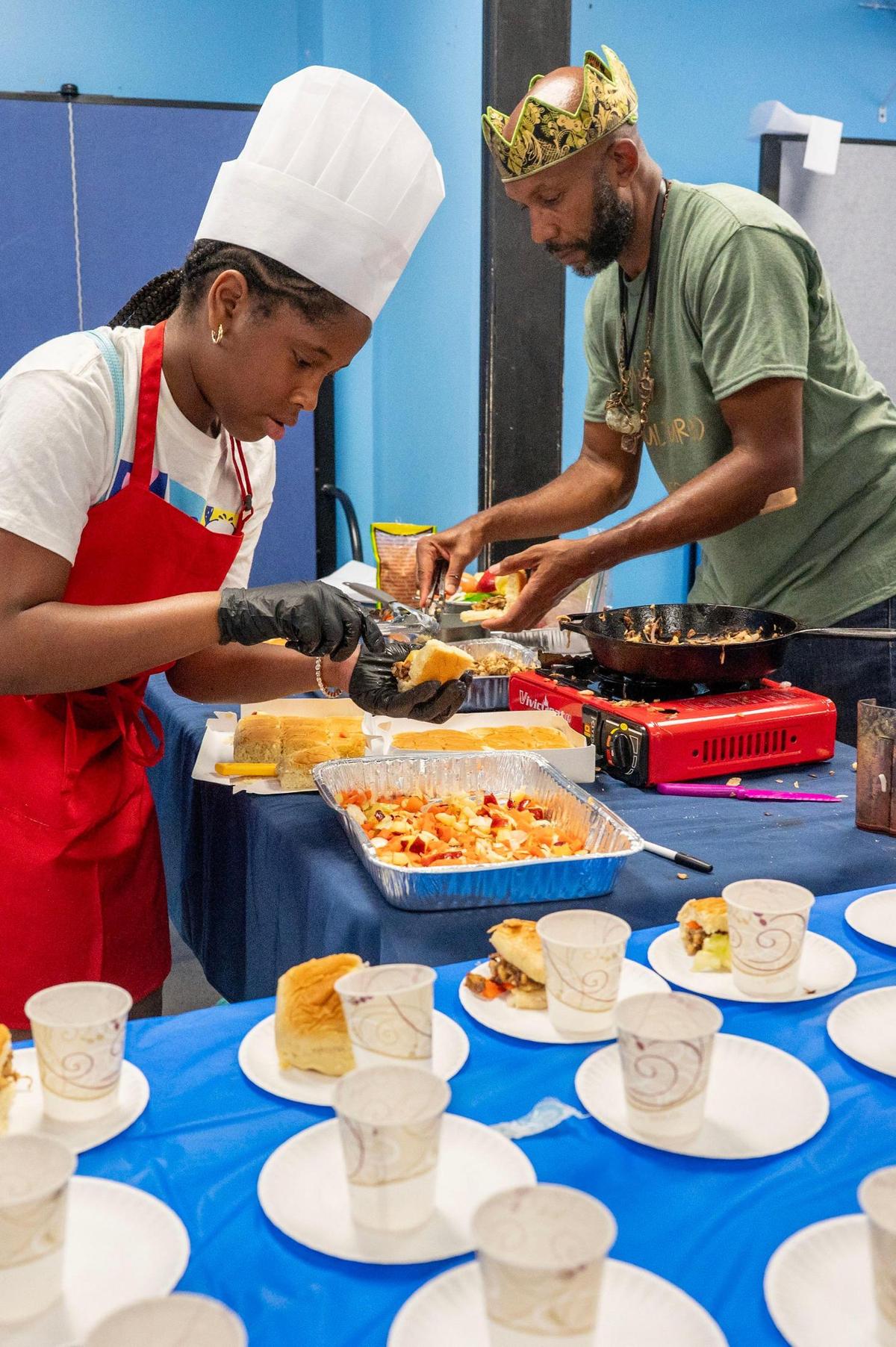 A.C.E. Academy student Kylie and Chef Shundo Moore plate their team’s Jamaican-style dish during the ‘Can U Cook?’ cooking class segment of the Young Moguls’ Summer Camp at A.C.E. Academy in Harrisburg, NC, Tuesday June 17, 2025. Many of the students within the Young Moguls program have their own businesses, many of which are food-focused, and A.C.E. Academy provides opportunities for them to sell their goods both within the school and with outside vendors.