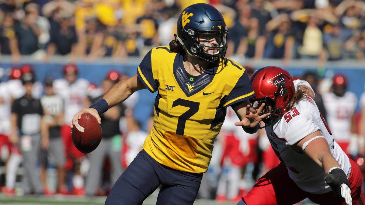 West Virginia quarterback Will Grier (7) scrambles to avoid a Texas Tech defender in October of 2017 (AP Photo/Raymond Thompson).