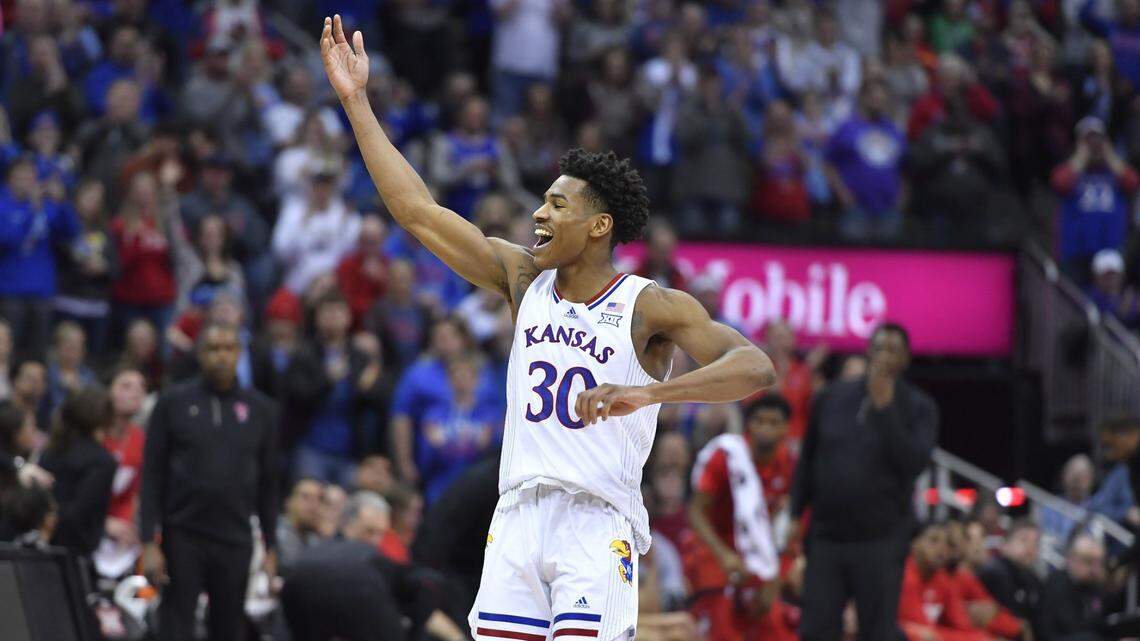 The Texas Tech bench, rear, could only watch as KU senior guard Ochai Agbaji got the celebration underway as time expired and KU claimed the Big 12 Tournament title, 74-65 Saturday at the T-Mobile Center in Kansas City.